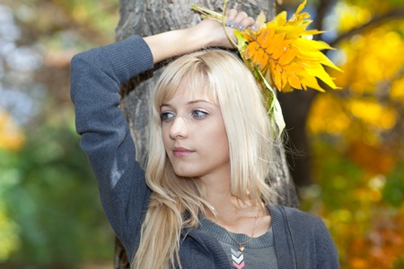 Young woman with a bouquet of leaves on a background of autumn parkの写真素材