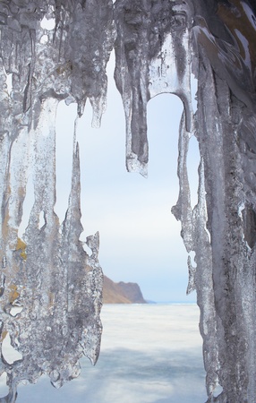 outdoor view of frozen baikal lake in winter with icicles on foregroundの写真素材