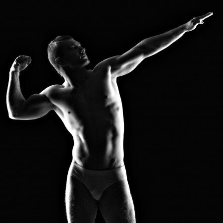 Silhouette of young athlete bodybuilder man on black の写真素材