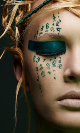 closeup portrait of beautiful young woman with hieroglyphic bodyartの写真素材