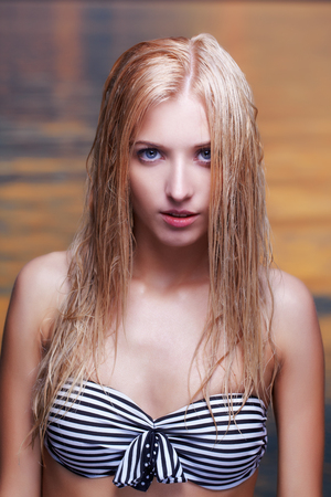 portrait of young beautiful blonde woman in bikini with wet hair  ocean on backgroundの写真素材
