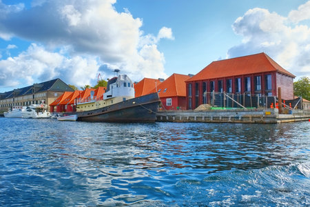 The houses with red roofs and quaysidenear with a moored ship main harbour location in Copenhagen, Denmark.のeditorial素材