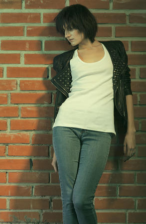Androgyny female model in Heroin chic style near brick wall. Old style tinted imageの写真素材