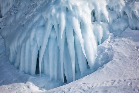 Icicles background on the ice wall on Baikal lake at winterの写真素材