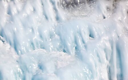 Icicles background on the ice wall on Baikal lake at winterの写真素材