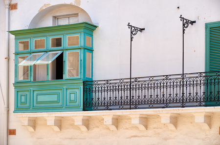 A traditional Maltese style green balcony with open windows in Valletta. Malta.の写真素材