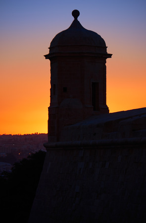 Night shot of The Guard tower on the tip of the St Peter and Paul counterguard against backlight of the sunset. Valletta, Maltaの写真素材