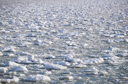 Lumps of snow and ice frazil on the surface of the freezing river water in early winter season