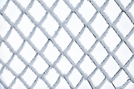 Metal net covered by crystals of ice hoarfrostの写真素材