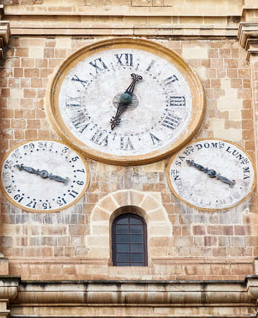 The clock on the bell and clock tower of St. John 's Co-Cathedral, showing the time and the day of the week and of the month. Valletta, Malta.の写真素材