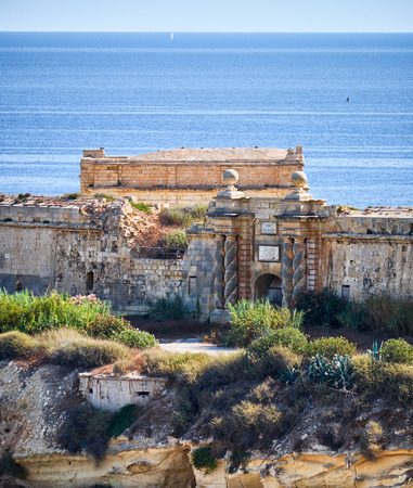 The south gate of Fort Ricasoli with the famous braids form colums as seen from Kalkara over the Rinella bay, Kalkara, Malta.の写真素材