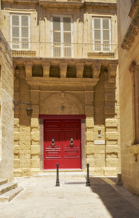 MDINA, MALTA - JULY 29, 2015:  The red  door of St. Dorothy's Convent  an international residence for young ladies - on the narrow streets of Mdina. Maltaのeditorial素材