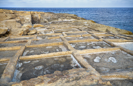 Historic old stone salt pans in Marsaskala coast, used for getting salt from sea water by evaporation, Maltaの写真素材