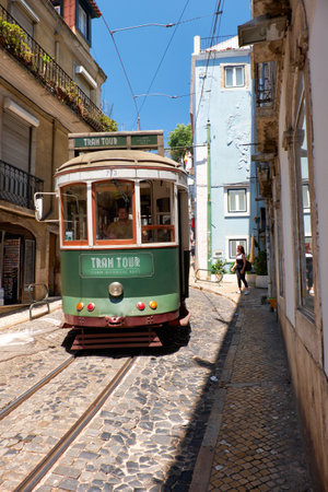 LISBON, PORTUGAL - JUNE 25, 2016:  Classic Remodelado tram tour number 28 navigates the steep incline between old houses of Alfama. Lisbon. Portugalのeditorial素材