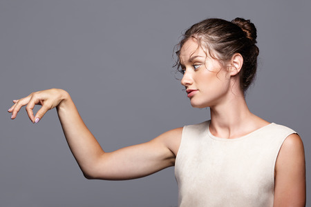 Young woman showing and presenting copy space by fingers.  Attractive female holding something on...