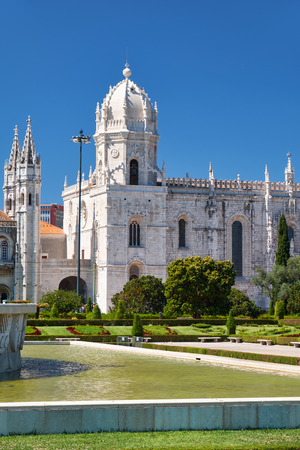 The view of Church of Santa Maria  of the Jeronimos Monastery through the beautiful garden on the  Empire square. Lisbon, Portugalの写真素材