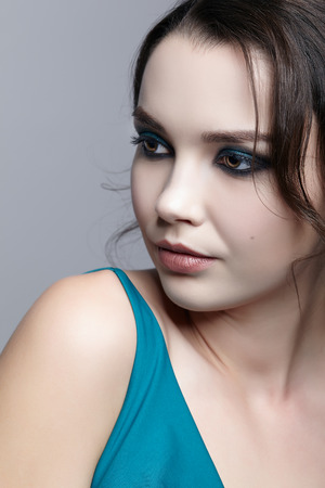 Portrait of young brunette woman on gray background.  Female beauty makeup concept.の写真素材
