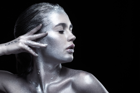 Beauty portrait of young gorgeous woman. Female with hand near face. Girl on black backgroundの写真素材