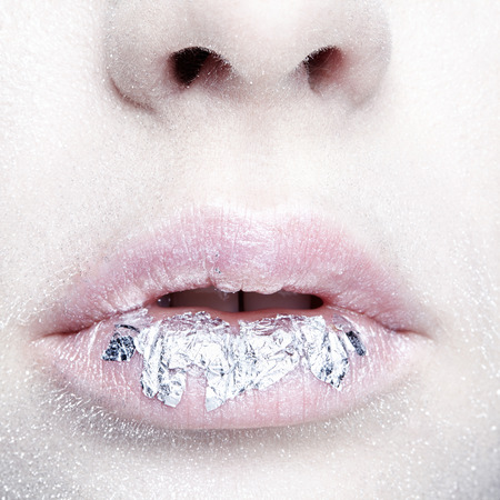 Female mouth with sparkles on lips. Closeup macro beauty portrait of young woman face. の写真素材
