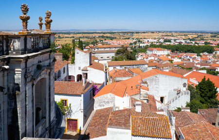 The view of balcony of the Evora Cathedral (Se) with stone torches and the nearby residential...
