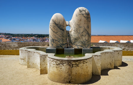 EVORA, PORTUGAL - JULY 1, 2016: A modern street art marble sculpture of couple sitting near fountain at the lookout point of Garden of Diana. Evora. Portugal.のeditorial素材