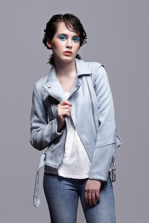 Portrait of female in blue jacket. Woman with unusual beauty makeup and wet hair. Girl with perfect skin, green pistachio colour eyes and blue shadows make-up.の写真素材