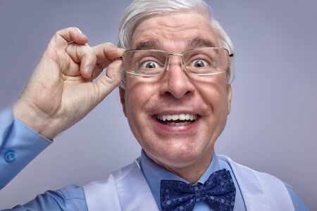 Close up portrait of funny smiling cheerful senior businessman clerk. Adult middle-aged man with...