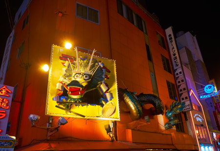 OSAKA, JAPAN - OCTOBER 13, 2019: The view of the famous gigantic Dragon sign on the wall of Kinryu Ramen Honten on the Dotonbori street in the night. Osaka. Japanのeditorial素材