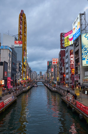 OSAKA, JAPAN - OCTOBER 14, 2019: The view of the Dotonbori canal in the evening colorful lights with its huge yellow Ferris wheel of Don Quijote store. Osaka. Japanのeditorial素材