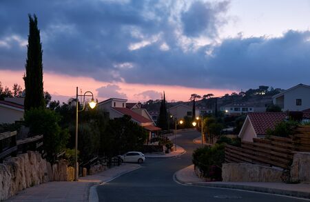 The view of the street with the line of residential houses of Pissouri village in the evening light. Limassol district. Cyprusの写真素材