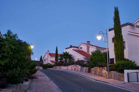 The view of the street with the line of residential houses of Pissouri village in the evening light. Limassol district. Cyprusの写真素材