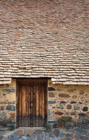 The view wooden door and the part of steep-pitched timber roof of the Church of Panagia Podithou....