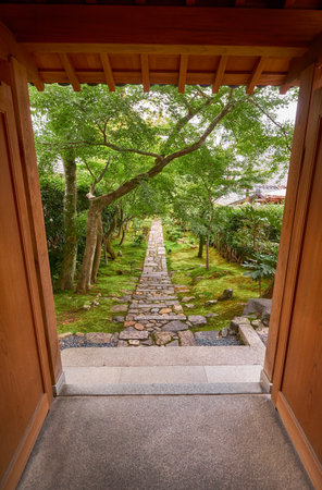 The view through the frame of old wooden gate to the garden with the stone road. Ryoan-ji temple. Kyoto.Japanのeditorial素材