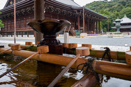 The water ablution pavilion for ceremonial purification (Chozuya or temizuya) with the Mieido main hall on the background. Chion-in temple complex.  Kyoto. Japanのeditorial素材