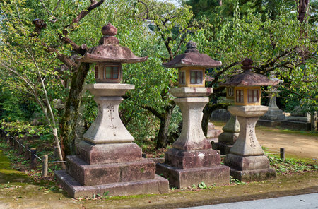 The view of the three kaku-doro traditional stone square lanterns along the footpath at the Kitano...