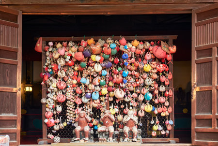 KYOTO, JAPAN - OCTOBER 18, 2019: The three hear no evil, see no evil, speak no evil monkeys surrounded by colorful balls (kukurizaru) with wishes at Yasaka Koshin-do temple. Kyoto. Japanのeditorial素材
