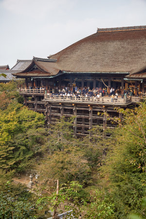 Kyoto, Japan - November 23, 2007: The large wooden stage in the main hall of Kiyomizu-dera temple which rises on the wooden pillars above the bright green vegetation of the hill. Kyoto. Japanのeditorial素材