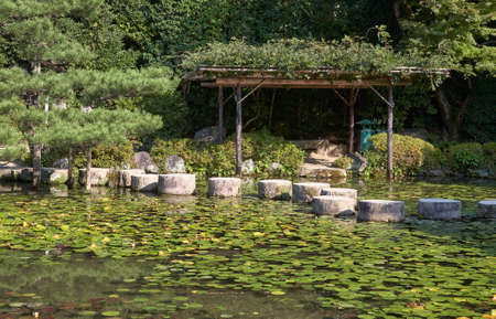 Garyu Bridge through the Soryu-ike pond covered with water lilies and pavilion at Middle (Naka...