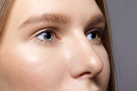 Closeup macro shot of human female face. Woman with natural face and eyes beauty makeup.