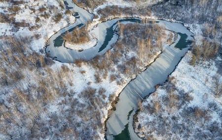 Aerial photo of Koen river under ice and snow. Beautiful winter landscape. Camera pointed down. Novosibirsk, Siberia, Russiaの写真素材