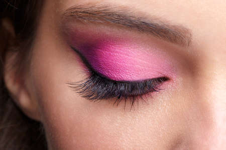 Closeup macro shot of closed human female eye. Woman with natural evening vogue face beauty makeup. Girl with perfect skin and pink eyes shadows.の写真素材