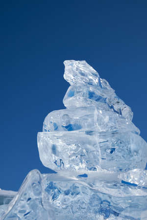 Ice floe crystal under blue sky background.の写真素材