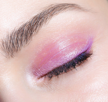 Closeup macro shot of closed human female eye. Woman with natural evening vogue face beauty makeup. Girl with perfect skin and pink eyes shadows.の写真素材