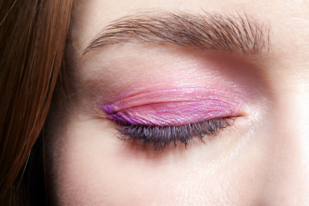 Closeup macro shot of closed human female eye. Woman with natural evening vogue face beauty makeup. Girl with perfect skin and pink eyes shadows.の写真素材