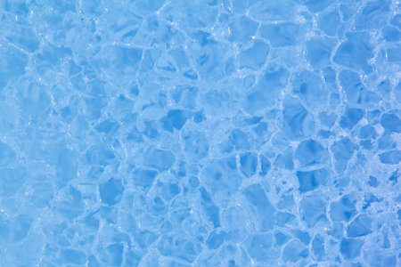 Texture of winter ice surface in the form of polygonal patterns. Blue natural ice background.の写真素材