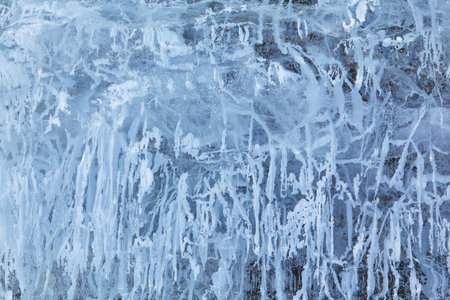 Texture of winter ice on a stone cliff. Blue natural ice background.の写真素材