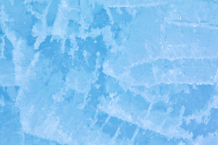 Texture of winter ice surface in the form of polygonal patterns. Blue natural ice background.の写真素材