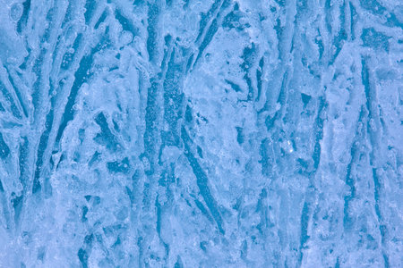 Texture of winter ice surface in the form of polygonal patterns. Blue natural ice background.の写真素材