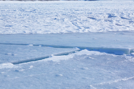 Winter ice landscape. Cracks in the ice field. Natural winter background.の写真素材