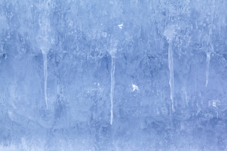 Texture of winter ice and icicles on a stone cliff. Blue natural ice background.の写真素材